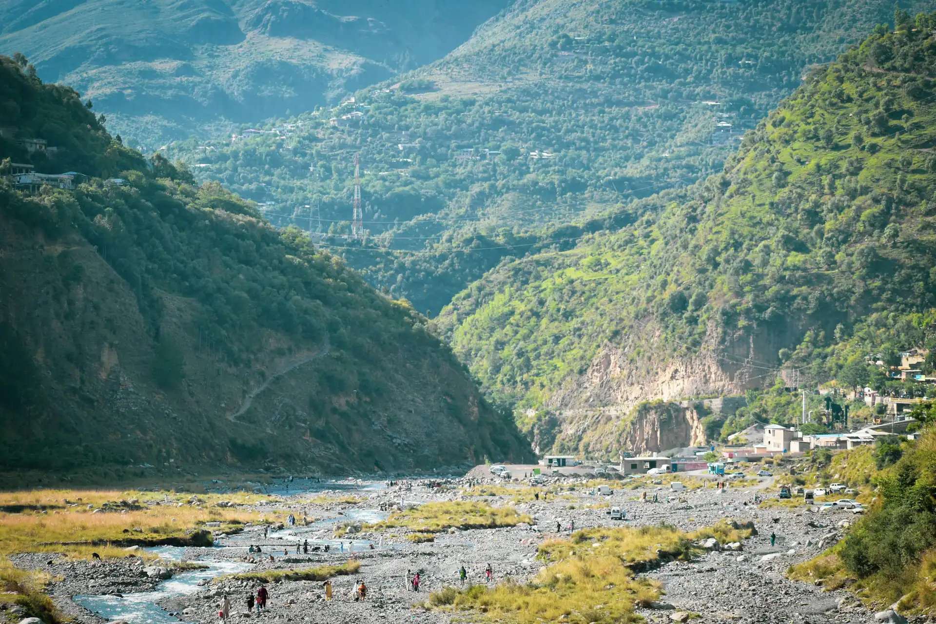 A river running through a green valley below the hills of Abbottabad.